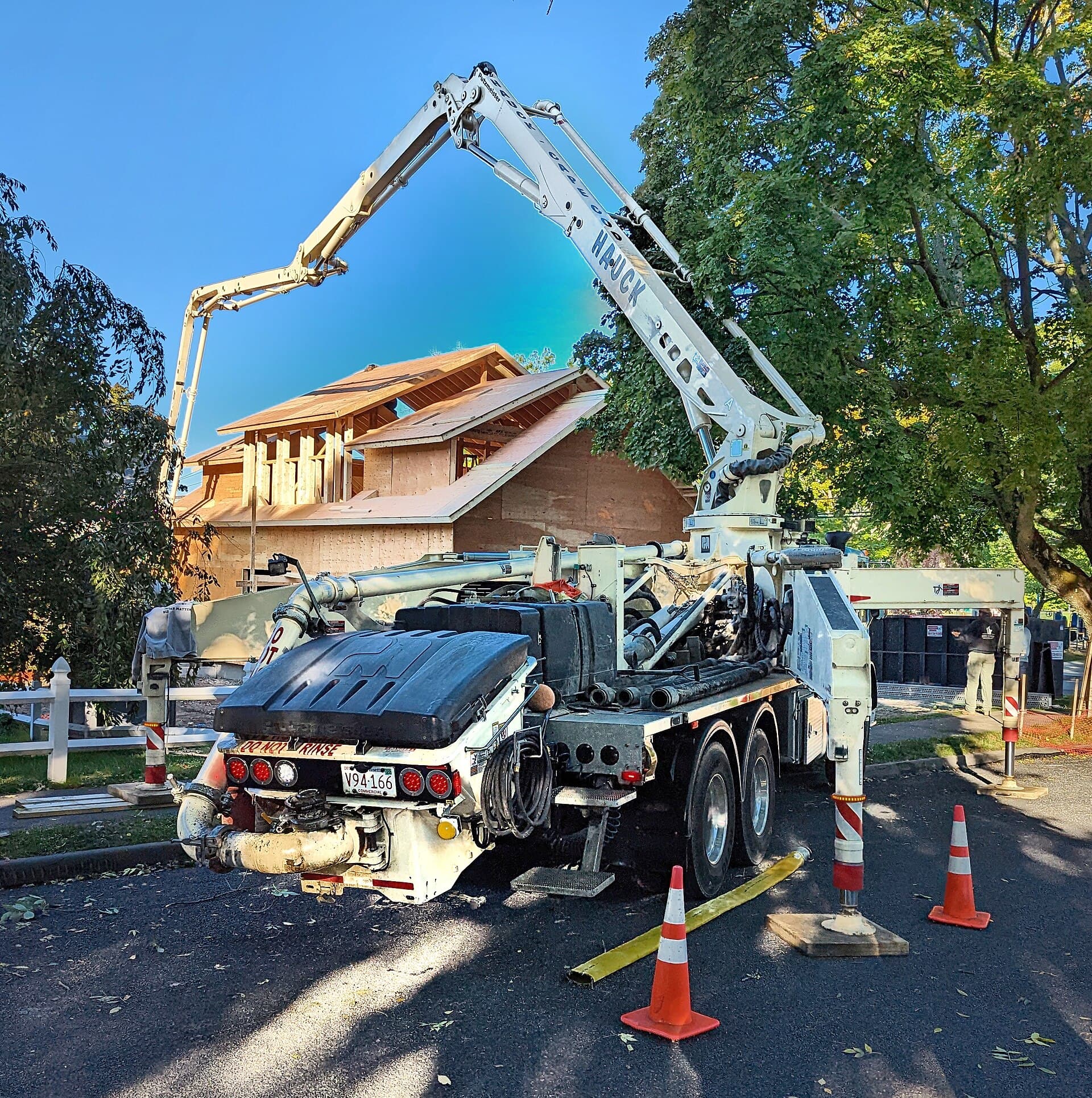 A concrete boom pump truck set up on a suburban street
