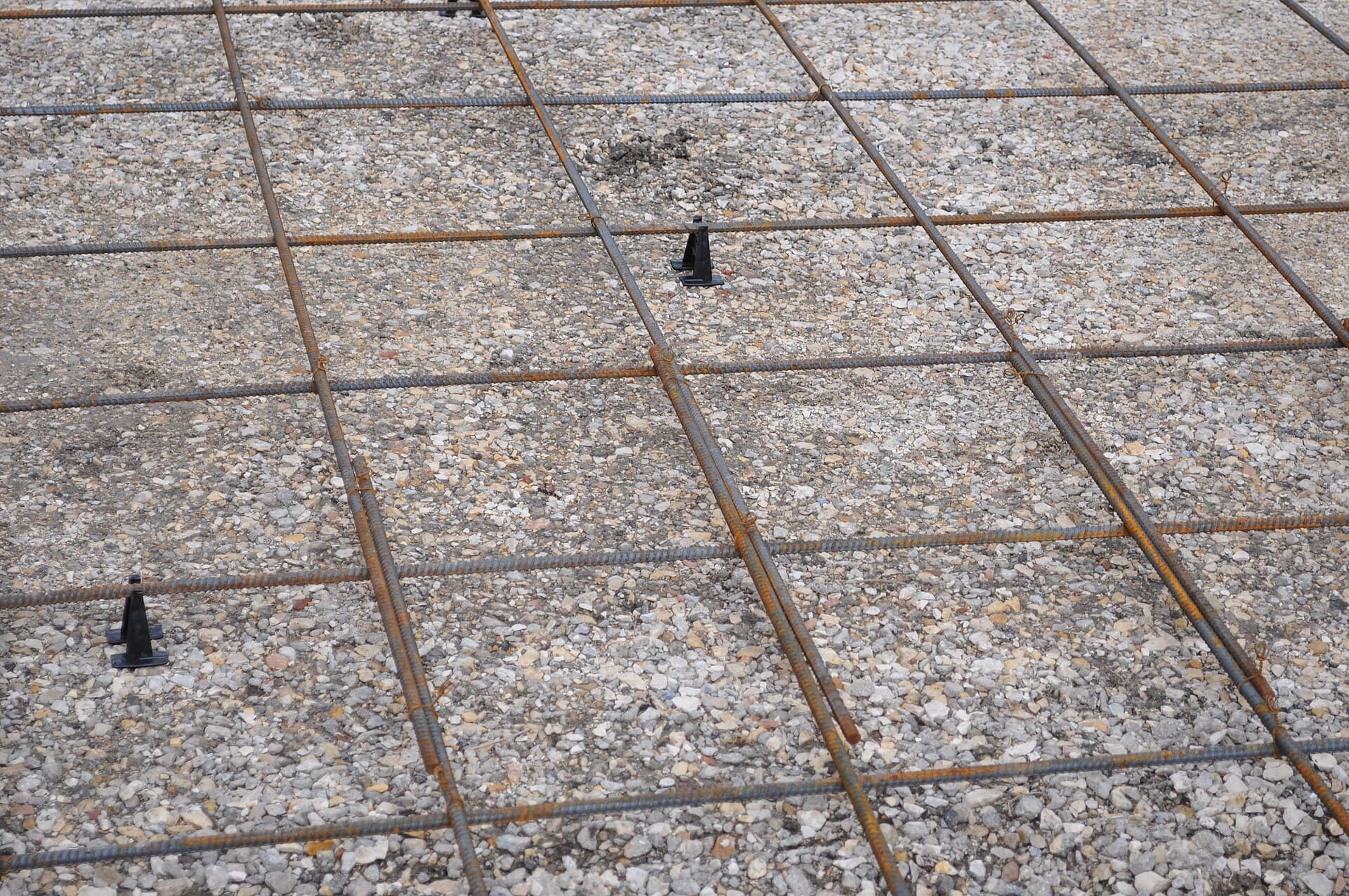 Tied steel reinforcement on chairs over a gravel base, ready for a driveway pour