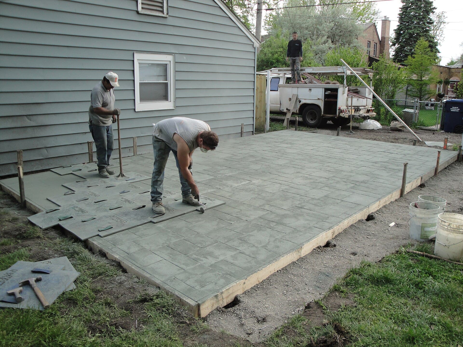 Concrete being stamped with an ashlar slate pattern